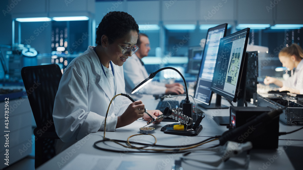 Modern Electronics Research, Development Facility: Black Female Engineer Does Computer Motherboard Soldering. Scientists Design Industrial PCB, Silicon Microchips, Semiconductors.