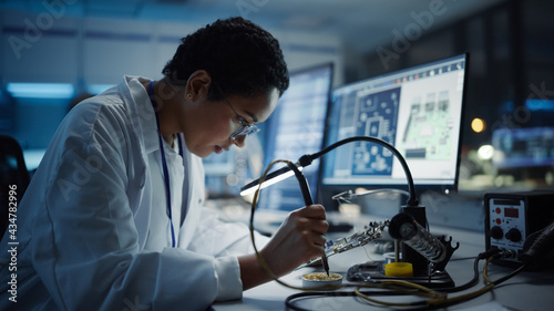 Modern Electronics Research, Development Facility: Black Female Engineer Does Computer Motherboard Soldering. Scientists Design Industrial PCB, Silicon Microchips, Semiconductors. Close-up Shot