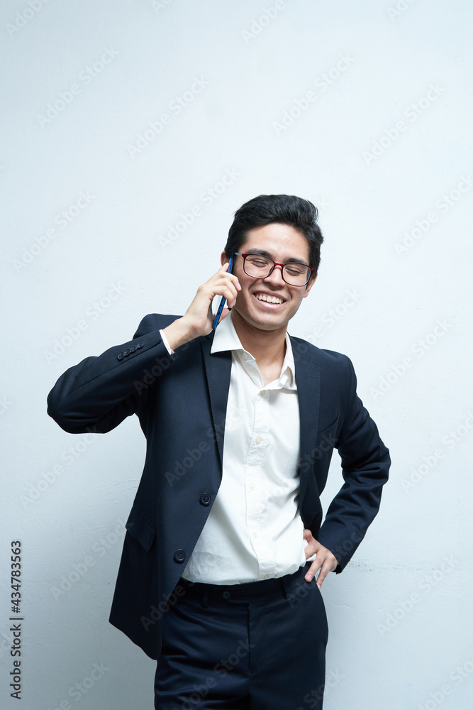 Young latin man with glasses wearing a suit talking on the phone holding it in his right hand, sorrowing for good news from work Young latin man with glasses wearing a suit talking on the phone holding it in his right hand, sorrowing for good news from work