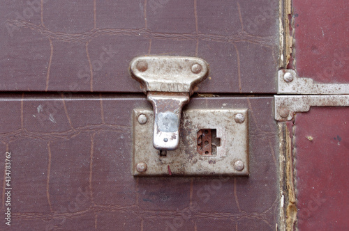 close up of old metal silver fastener on a large vintage brown closed suitcase 
