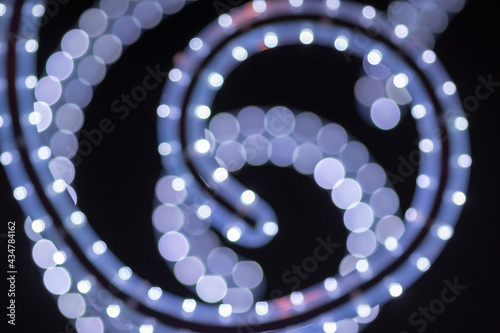 Abstraction in the form of spirals of white dots on a dark background. Out of focus.