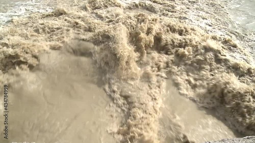 The gray, seething and boiling water of the deep river flows with a roar. The video was shot in close-up.