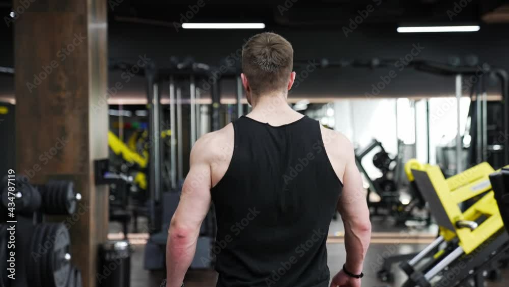 Young strong man at gym. Bodybuilding guy with perfect body starting to hard training Young strong man at gym. Bodybuilding guy with perfect body starting to hard training