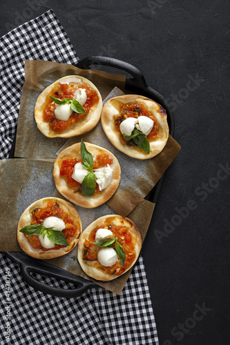 Homemade mini pizzas margarita with tomato, mozzarella and basil