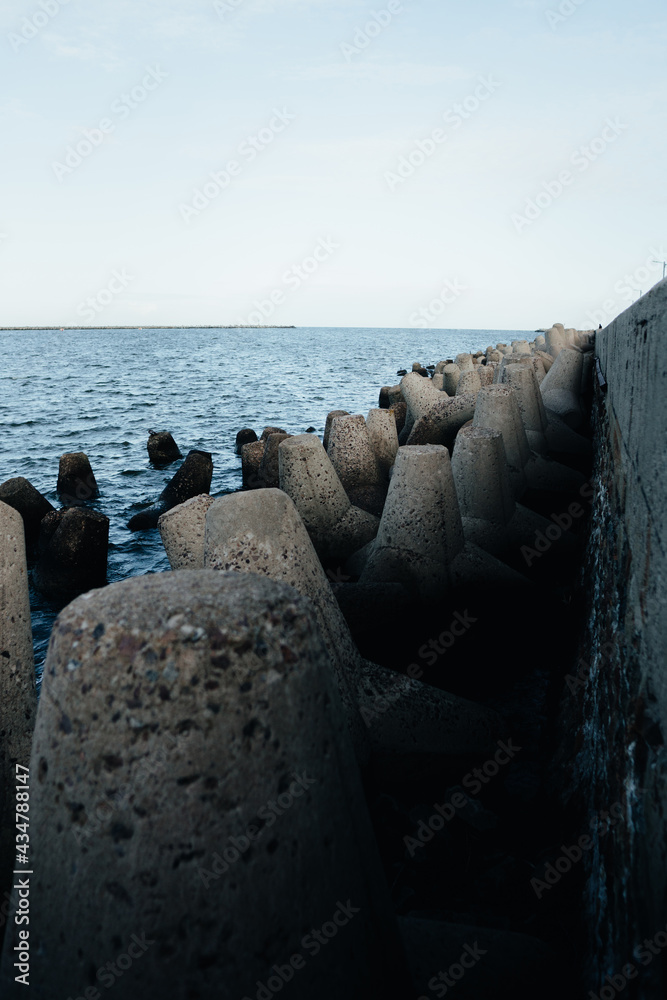 Concrete tetrapod of dark and light breakwaters in sea water Concrete tetrapod of dark and light breakwaters in sea water