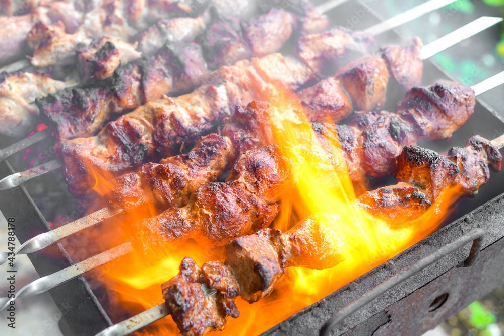 The flame envelops the skewered meat, which is fried over burning coals.