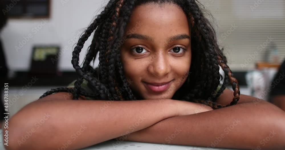 Preteen girl smiling at camera, mixed race black ethnicity. African child smile close-up face