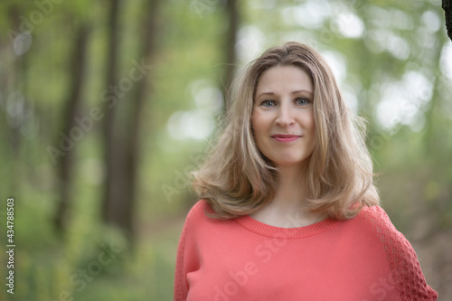 Portrait of a young beautiful blonde woman in a summer forest.