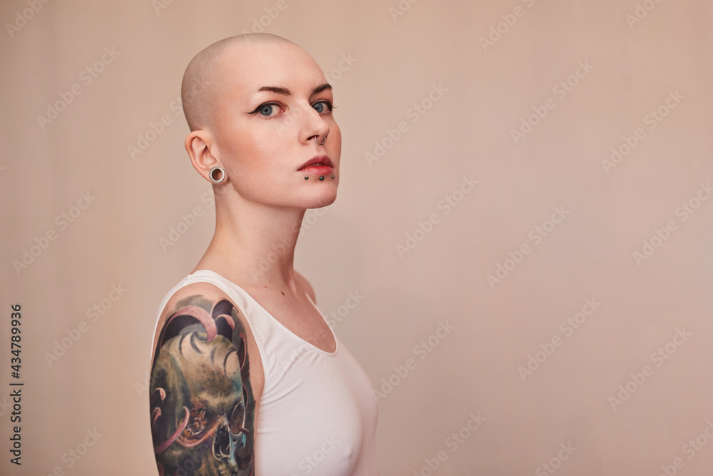 Bald masculine woman posing fashionably with serious emotions - obrazy, fototapety, plakaty 