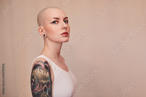 Bald masculine woman posing fashionably with serious emotions