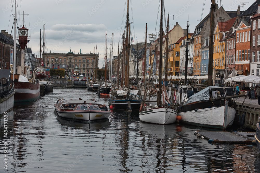 Fototapeta premium Copenhagen, Denmark - Juli 1, 2020 Street view of the colorful building in Nyhavn in Cophenhagen with people walking the street in front. High quality photo