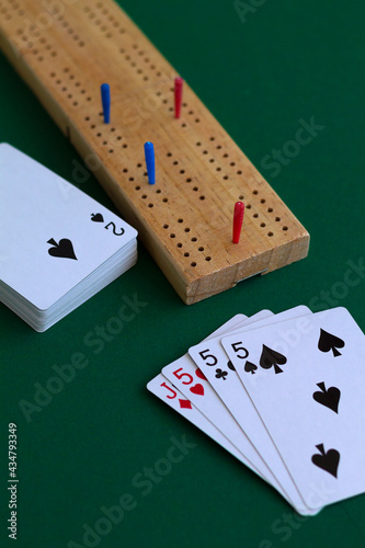 cribbage wooden games.playing card and cribbage board on the green.playing cards with deck on the table. combination of cards on a casino desk background with copy space.top view