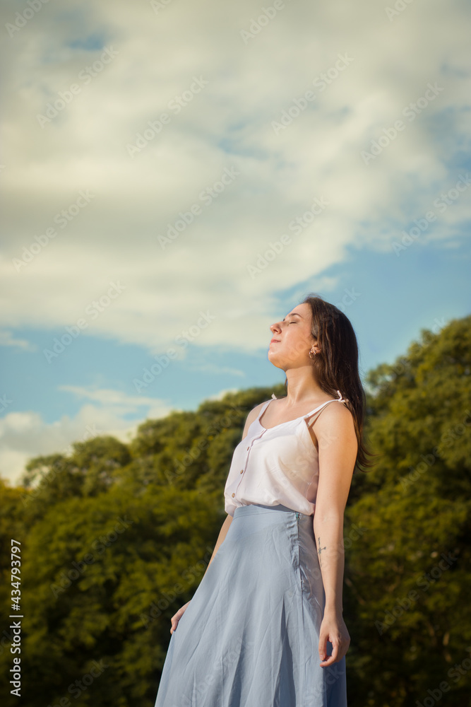 Young woman under the sun and big sky.