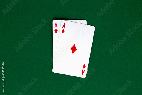 two red aces. playing cards with blue deck on the green table. combination of cards on a green casino desk background. top view. poker