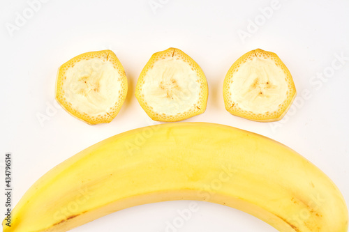 Sliced and whole banana close up on white background