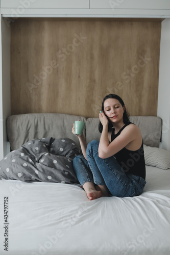 girl in the morning in bed with a cup of coffee