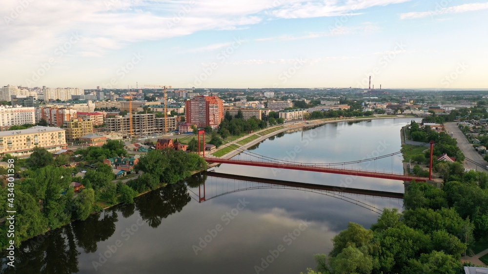 Suspension bridge in the city of Penza, Russia. Red Suspension Metallic Bridge. Red suspension bridge over the river.
