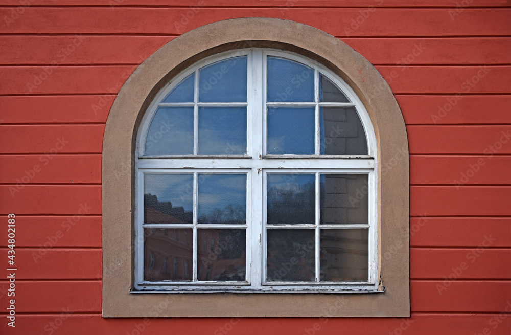 Old wooden window with arch on red wall Old wooden window with arch on red wall