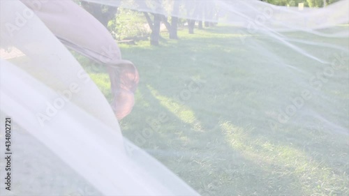 the bed linen is blowing in the wind. Street, sunny day. White apple blossom.