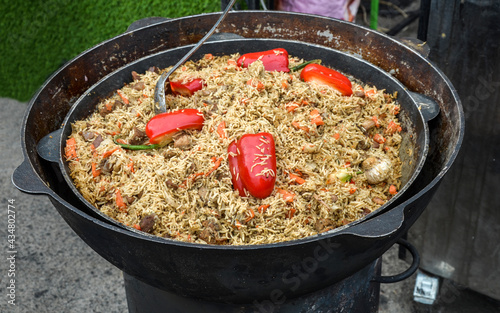 Pilaf with rice and meat In cauldron for sell in street food market, Uzbek cuisine, in Kyiv Ukraine, Closeup