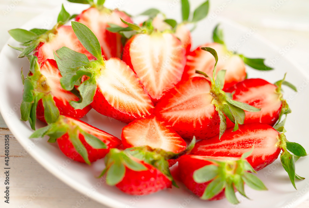 Ripe Strawberries in a White Plate. Fresh Juicy Strawberries with Leaves. Summer Berries Background. Ripe Strawberries in a White Plate. Fresh Juicy Strawberries with Leaves. Summer Berries Background.