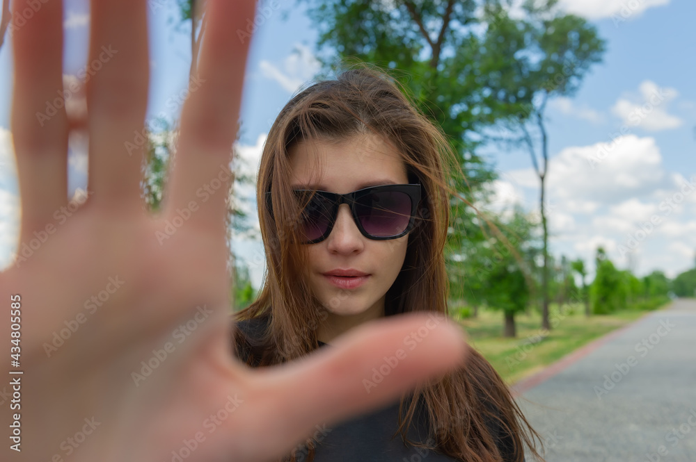 pretty woman in sunglasses makes a hand gesture to prohibit taking pictures. pretty woman in sunglasses makes a hand gesture to prohibit taking pictures.