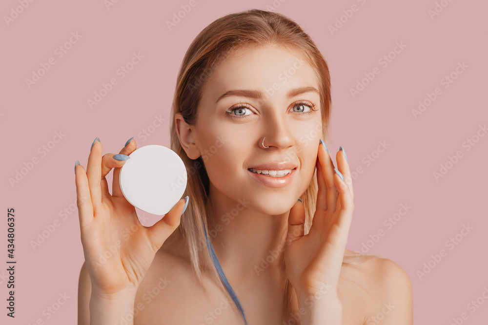 Girl make face beauty masks. Anti-wrinkle cream for the freshness of the skin around the eyes. Woman take care of youthful skin. Model laughing and having fun in spa on pink background Girl make face beauty masks. Anti-wrinkle cream for the freshness of the skin around the eyes. Woman take care of youthful skin. Model laughing and having fun in spa on pink background
