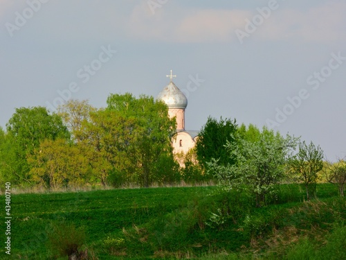 The dome of the church against the backdrop of the river and green trees