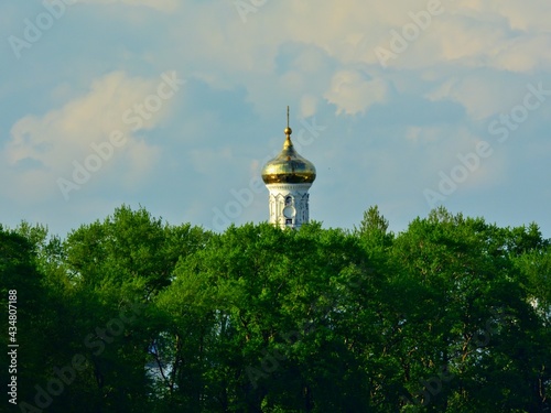 The dome of the church against the backdrop of the river and green trees