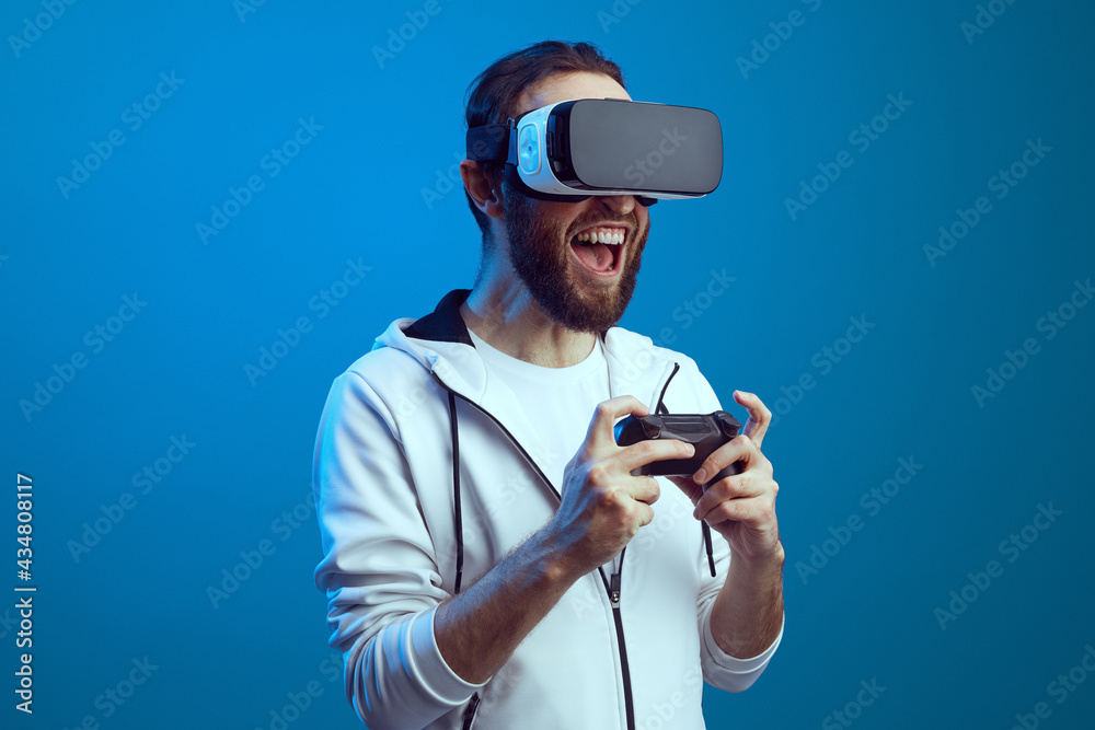 Young excited bearded man standing with the VR equipment and playing Young excited bearded man standing with the VR equipment and playing