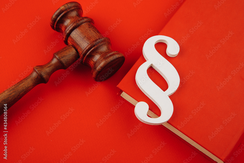 Paragraph symbol is on a book and gavel on red. Law and justice concept