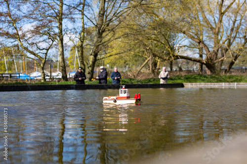 Woodbridge, Suffolk, UK April 12 2021: Old friends meeting up and sailing their model yachts on a pond
