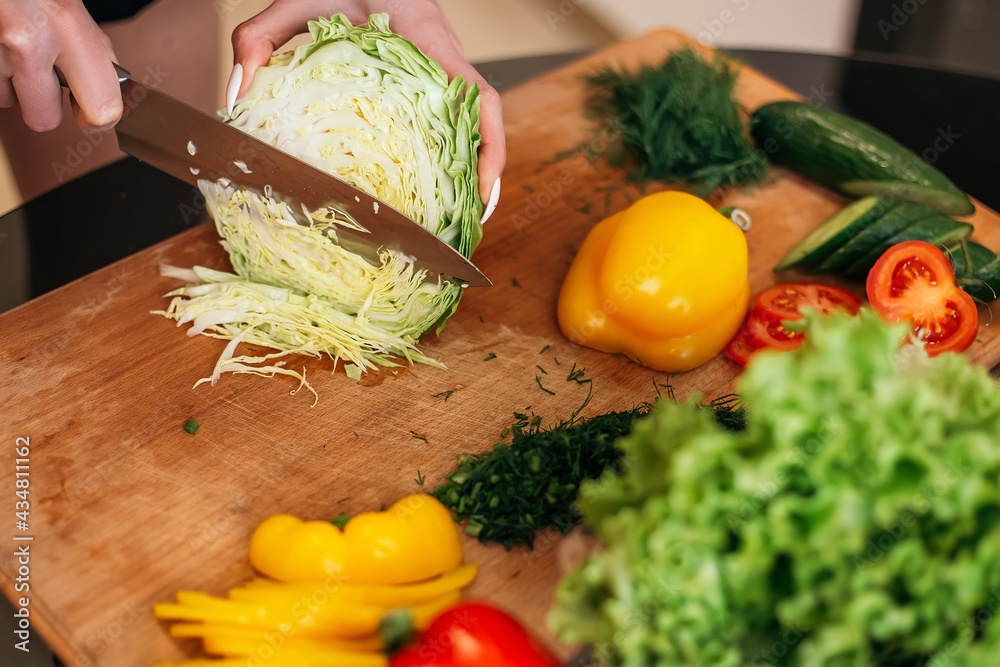 Close up shot woman standing kitchen hold hand cabbage products fruits vegetables wooden cutting board. Lady preparing breakfast lunch after training, want cook healthy food, copyspace.
Close up shot woman standing kitchen hold hand cabbage products fruits vegetables wooden cutting board. Lady preparing breakfast lunch after training, want cook healthy food, copyspace.