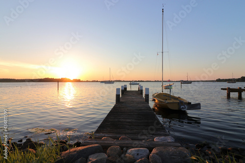 Romantic jetty with sailboat at the dreamy fishing village Maasholm with the Schlei Fjord. © Lars Gieger