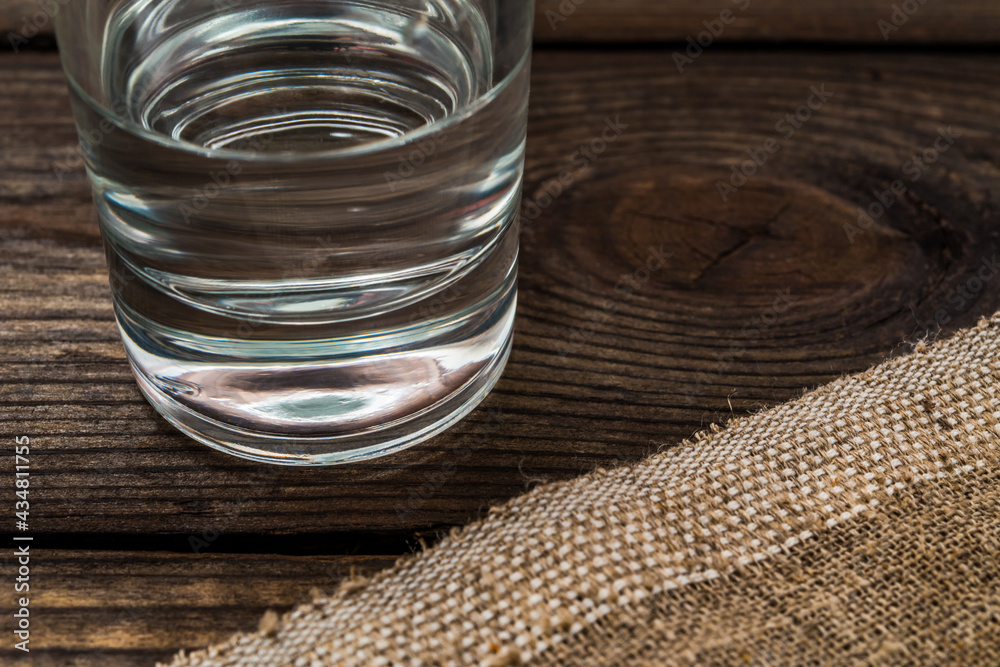 Shot of vodka with piece of cloth on an old wooden table. Close up view Shot of vodka with piece of cloth on an old wooden table. Close up view