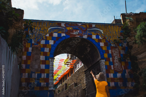 Fotografie mujer joven señalando el arco Gucumatz ubicado en Chichicastenango Quiché Guatem