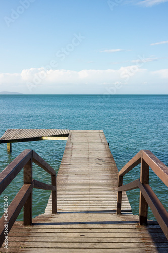 Fototapeta Naklejka Na Ścianę i Meble -  Deck on the beach with a beautifull landscape view of the ocean and nature. Blue sky