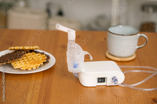 Nebulizer on the table with a cup and cookies