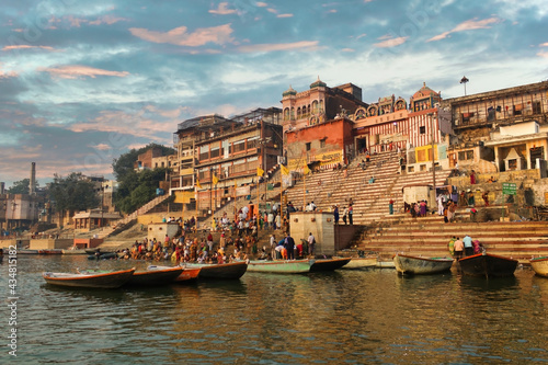 Varanasi, India: Crowd of people tourist and pilgrims in Kedar ghat participating in holy rituals and prayer in the bank of Ganges river against old architecture and cityscape © Arpan
