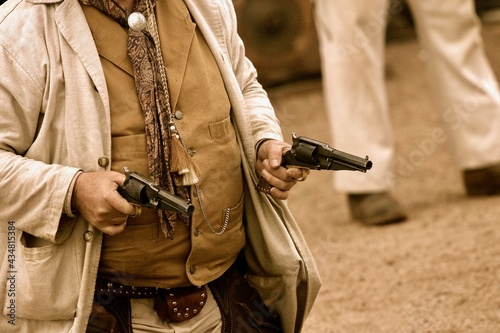 A sepia toned close up view of a cowboy ready to fire a handgun during a Wild West showdown in the desert outside of Phoenix, Arizona.