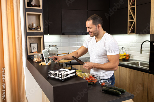 Happy man enjoying cooking from the comfort of his home kitchen