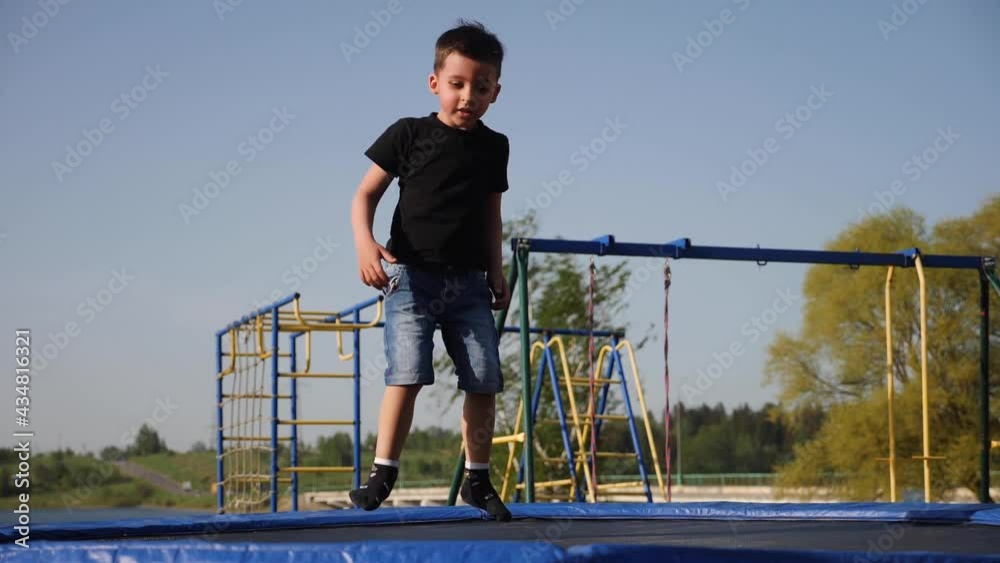 baby boy jumping having fun on a trampoline standing on the street baby boy jumping having fun on a trampoline standing on the street