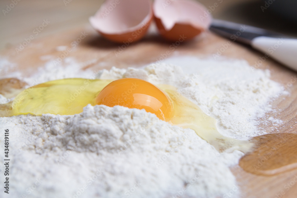 Fresh raw chicken eggs in flour close-up. Mix broken raw eggs and wheat flour, homemade cookies Fresh raw chicken eggs in flour close-up. Mix broken raw eggs and wheat flour, homemade cookies