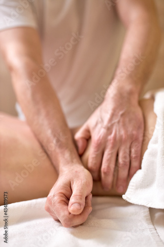 Female enjoying back and spine massage in spa. Focus on Male Masseur hands. Close-up. Professional massage therapist treating female patient. Relaxation,beauty,body and face treatment concept