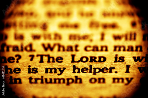 A macro shot of a Bible text with the words  of Psalm 118 verse 7: The Lord is my helper. Low depth of field