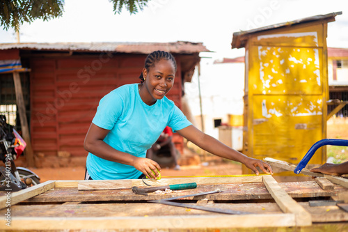 close up of a professional carpenter taking measurement of wood she wants to work on photo