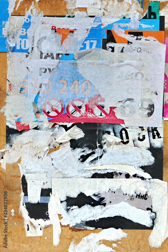Fototapeta premium Vertical Old Wall Background With Torn Posters, Stickers and Advert. Old Grunge Ripped Torn Vintage Posters and Ads Background Texture.
