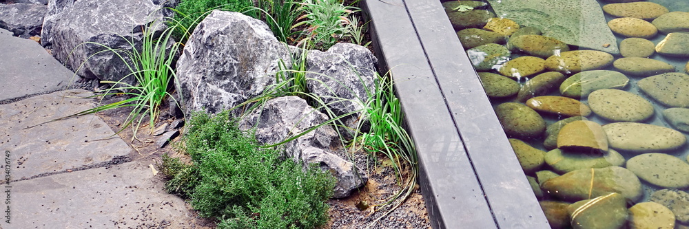 Decorative Above Ground Pond in Japanese Style in Back Yard Garden And Stone Footpath. Modern Backyard Garden Landscaping with Designed Elements. Family Rest Area at Small Designed Pond In Garden. Decorative Above Ground Pond in Japanese Style in Back Yard Garden And Stone Footpath. Modern Backyard Garden Landscaping with Designed Elements. Family Rest Area at Small Designed Pond In Garden.