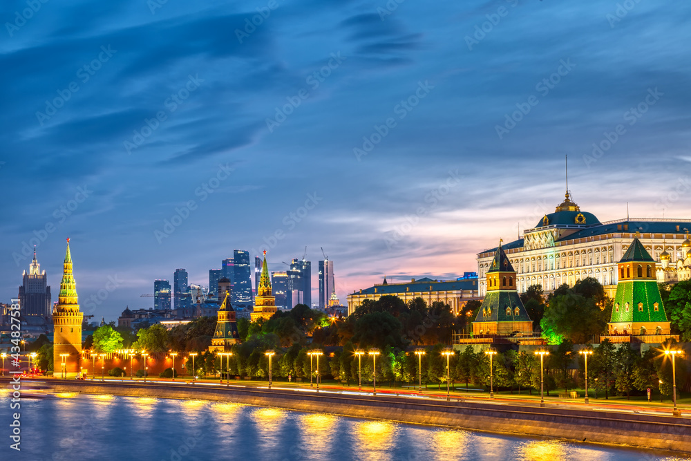 View of the Moscow Kremlin and Moscow City Skyscrapers along the quay of the Moscow river during evening sunset blue hour