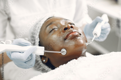 Girl doing facial procedures to beautician